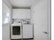 Laundry room area featuring modern front load washer and dryer and overhead cabinets at 131 Sandstone Cir, Venice, FL 34293