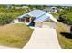 Aerial view of the charming home with a well-manicured lawn, neutral stucco, a spacious driveway and a two-car garage at 13452 High Springs Ave, Port Charlotte, FL 33981