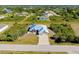 Overhead view of a charming home with a metal roof, surrounded by lush greenery and other neighborhood homes at 13452 High Springs Ave, Port Charlotte, FL 33981