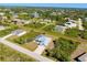 An aerial view of a charming house with a blue and white roof, surrounded by lush greenery and neighborhood at 13452 High Springs Ave, Port Charlotte, FL 33981