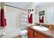 Bright bathroom features a shower-tub combination with a stylish beach-themed shower curtain and brown vanity at 13452 High Springs Ave, Port Charlotte, FL 33981