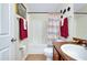 Bright bathroom features a shower-tub combination with a stylish beach-themed shower curtain and brown vanity at 13452 High Springs Ave, Port Charlotte, FL 33981