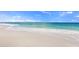 Expansive white sandy beach with clear turquoise waters and gentle waves, perfect for a peaceful getaway at 13452 High Springs Ave, Port Charlotte, FL 33981