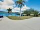 Exterior view of the community clubhouse featuring vibrant blue paint, palm trees, and manicured landscaping at 13452 High Springs Ave, Port Charlotte, FL 33981