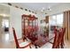 Formal dining room featuring a large wooden table, elegant china cabinet, and stylish chandelier at 13452 High Springs Ave, Port Charlotte, FL 33981