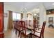 Spacious dining room with a large wooden table, decorative chairs, chandelier, and natural light at 13452 High Springs Ave, Port Charlotte, FL 33981