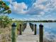 Scenic waterfront view from a private wooden dock with serene water and blue sky reflections at 13452 High Springs Ave, Port Charlotte, FL 33981