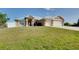 Inviting home featuring an attached two-car garage, a neatly landscaped lawn, and a welcoming front entrance at 13452 High Springs Ave, Port Charlotte, FL 33981
