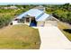 Charming house showcasing a well-manicured lawn and a durable-looking, light-colored metal roof at 13452 High Springs Ave, Port Charlotte, FL 33981