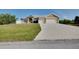 Charming home with a well-manicured lawn, long driveway, and attached two-car garage, offering comfort and curb appeal at 13452 High Springs Ave, Port Charlotte, FL 33981