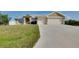 Charming single-story home with stucco exterior, lush lawn, and two-car garage at 13452 High Springs Ave, Port Charlotte, FL 33981