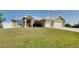 Inviting house with a manicured lawn leading up to two-car garage, accented by a light-colored roof at 13452 High Springs Ave, Port Charlotte, FL 33981
