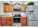 Stylish kitchen featuring stainless steel appliances, wood cabinets, and tiled floors at 13452 High Springs Ave, Port Charlotte, FL 33981