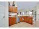 Spacious kitchen featuring wooden cabinets, stainless steel dishwasher, and breakfast bar for a modern look at 13452 High Springs Ave, Port Charlotte, FL 33981