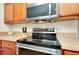 Close-up of a modern oven and cooktop beneath a stainless steel microwave, showcasing stylish kitchen appliances at 13452 High Springs Ave, Port Charlotte, FL 33981