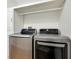 Efficient laundry area features LG silver washer and dryer, white cabinets and a convenient hanging rack at 13452 High Springs Ave, Port Charlotte, FL 33981