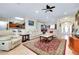 Bright open-concept living room with tile floors, modern furniture, and bar-top seating to kitchen at 13452 High Springs Ave, Port Charlotte, FL 33981