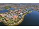 An aerial view highlighting the community clubhouse, pool and recreational facilities near a scenic lake at 13897 Umbria St, Venice, FL 34293