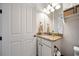Bathroom features a granite-topped vanity, white cabinetry, and a toilet at 13897 Umbria St, Venice, FL 34293