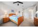 Bedroom with wood frame bed, neutral walls, ceiling fan, and an ensuite bathroom at 13897 Umbria St, Venice, FL 34293