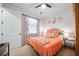Bright bedroom with neutral walls, ceiling fan, carpet floors, and floral accents at 13897 Umbria St, Venice, FL 34293