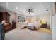 Spacious bedroom featuring neutral walls, ceiling fan, carpet floors, and tray ceiling at 13897 Umbria St, Venice, FL 34293