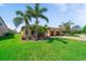 Beautiful home with a well-manicured lawn, paver driveway, and tropical landscaping at 13897 Umbria St, Venice, FL 34293