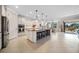 Bright kitchen with granite island, barstool seating, tiled floors, modern appliances, and access to an outdoor patio at 13897 Umbria St, Venice, FL 34293