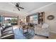 Cozy living room with a ceiling fan, entertainment center, and comfortable seating, leading to an outdoor space at 13897 Umbria St, Venice, FL 34293