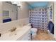 Well-maintained bathroom featuring a shower with a blue geometric curtain, a white vanity, and tile floors at 1460 Everest Rd, Venice, FL 34293