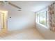 Sunlit bedroom with tile floors and large window with coral patterned curtains at 1460 Everest Rd, Venice, FL 34293