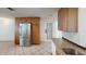 Bright kitchen with tile flooring, wood cabinets, stainless steel refrigerator, and granite countertops at 1460 Everest Rd, Venice, FL 34293