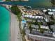 Stunning aerial view of beachfront property with pristine turquoise water and lush landscaping at 1555 Tarpon Center Dr # 156, Venice, FL 34285