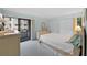 Well-lit bedroom features sliding glass doors leading to balcony, complemented by neutral tones and a dresser at 1555 Tarpon Center Dr # 156, Venice, FL 34285