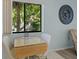 Sunlit breakfast nook features an extendable wood table, comfortable seating, and a decorative wall clock at 1555 Tarpon Center Dr # 156, Venice, FL 34285