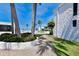 A community pool, lush landscape, white exterior and tropical palm trees enhance the community's exterior appeal at 1555 Tarpon Center Dr # 156, Venice, FL 34285