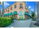 Charming commercial building with awnings and outdoor seating, surrounded by lush landscaping at 1555 Tarpon Center Dr # 156, Venice, FL 34285