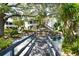 Beautiful exterior view showing lush landscaping, a stone waterfall, and a charming bridge at 1555 Tarpon Center Dr # 156, Venice, FL 34285