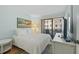 Bright main bedroom with sliding glass doors leading to balcony, complemented by neutral tones and a cozy rug at 1555 Tarpon Center Dr # 156, Venice, FL 34285