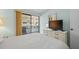 Comfortable bedroom with sliding glass door access to the balcony, complemented by a TV and neutral decor at 1555 Tarpon Center Dr # 156, Venice, FL 34285