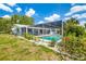 Beautiful backyard featuring a screened-in pool, lush lawn, and well-maintained landscaping at 1585 Keyway Ct, Englewood, FL 34223