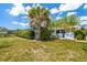 Beautiful backyard with a manicured lawn, privacy hedges, and access to the inviting screened-in pool area at 1585 Keyway Ct, Englewood, FL 34223