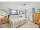 Comfortable bedroom with a queen bed, patterned bedding, light-colored walls, and ample natural light from multiple windows at 1585 Keyway Ct, Englewood, FL 34223