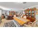 Spacious dining area features a wooden table, upholstered chairs, and a bench, adjacent to a living space at 1585 Keyway Ct, Englewood, FL 34223