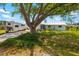 Charming home exterior with a large tree, spacious driveway, and inviting landscaping at 1585 Keyway Ct, Englewood, FL 34223