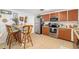 Bright kitchen featuring wood cabinets, stainless steel appliances, a breakfast bar, and tile flooring at 1585 Keyway Ct, Englewood, FL 34223