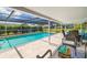 Relaxing screened-in pool area with ample seating and a view of the surrounding greenery, perfect for outdoor enjoyment at 1585 Keyway Ct, Englewood, FL 34223