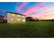 Large backyard with lush green grass, a playset, and view of the pond at 1951 E Isles Rd, Port Charlotte, FL 33953