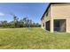 Spacious backyard featuring a lush lawn, mature trees, and a charming screened lanai for outdoor relaxation at 1951 E Isles Rd, Port Charlotte, FL 33953