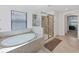 Bright bathroom featuring a large soaking tub, tiled floors, and a frameless glass shower at 1951 E Isles Rd, Port Charlotte, FL 33953